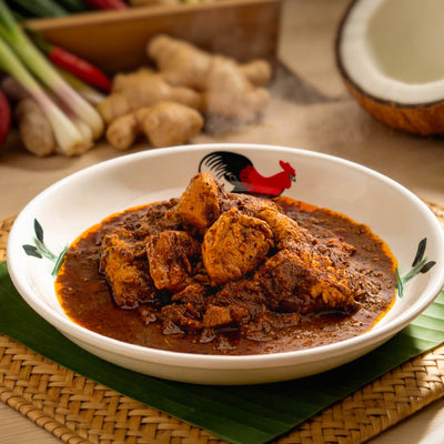 Rendang pork belly served on a white plate with aromatic spices