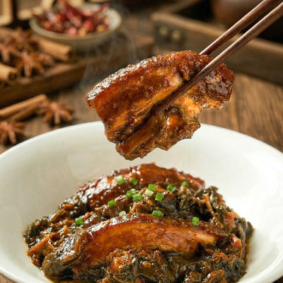 Steamed pork belly with preserved vegetable held by chopsticks