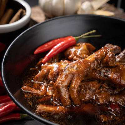 Teochew braised chicken feet with red chillies in a black pan